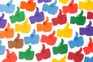 Multiple bright colored thumbs up hand gesture icons scattered across white background in blue, green, red, orange, yellow, and purple.