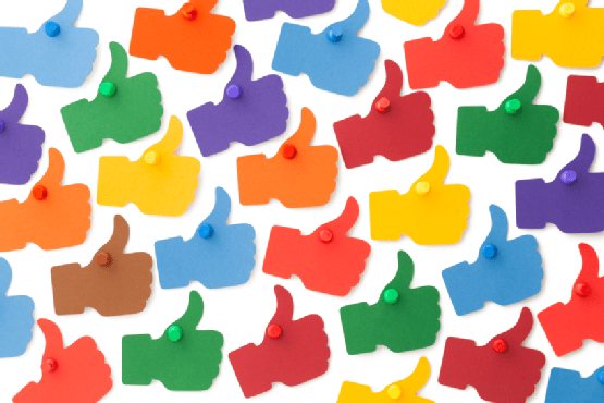 Multiple bright colored thumbs up hand gesture icons scattered across white background in blue, green, red, orange, yellow, and purple.