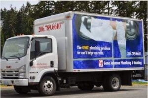 White GMC box truck with blue advertising wrap displaying plumbing services and phone number 206.789.6610.
