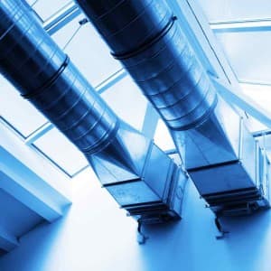 Industrial ventilation ducts and ductwork installed in a modern home system with blue-toned lighting.