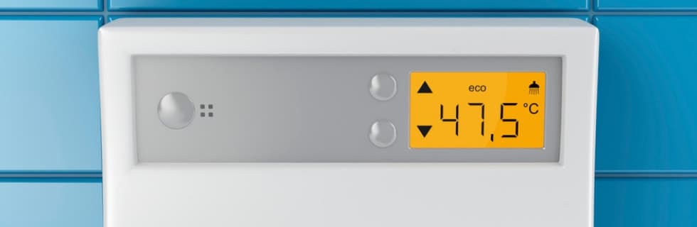 White digital thermostat mounted on blue tiled wall showing eco mode with temperature reading of 47.5°C on yellow display screen.