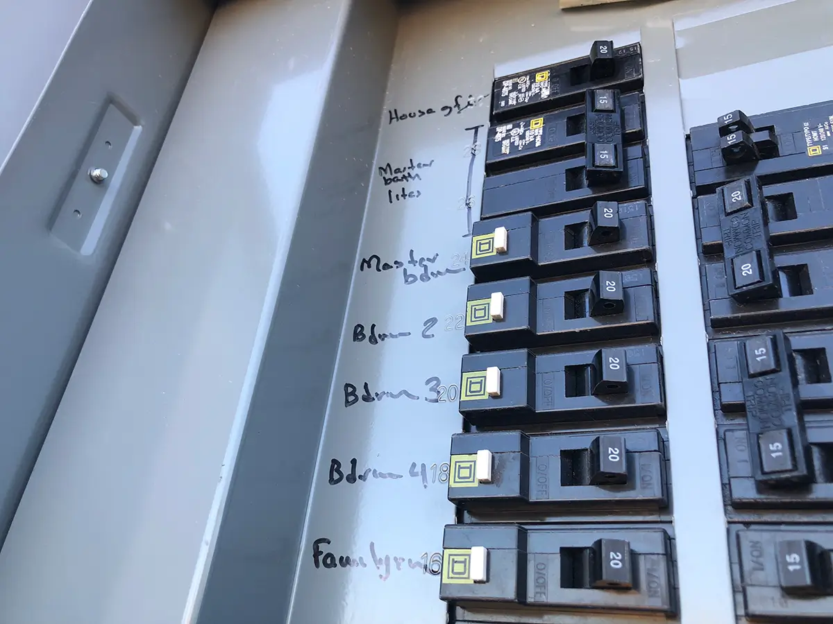 Home electrical circuit breaker panel with multiple 20-amp breakers and handwritten labels including Master Bath, Master Bedroom, Blvd zones, and Fam Rm.