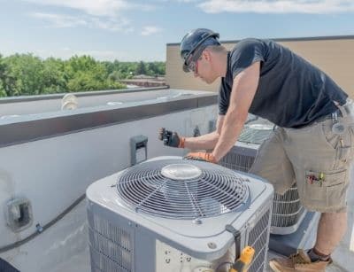 technician servicing HVAC unit